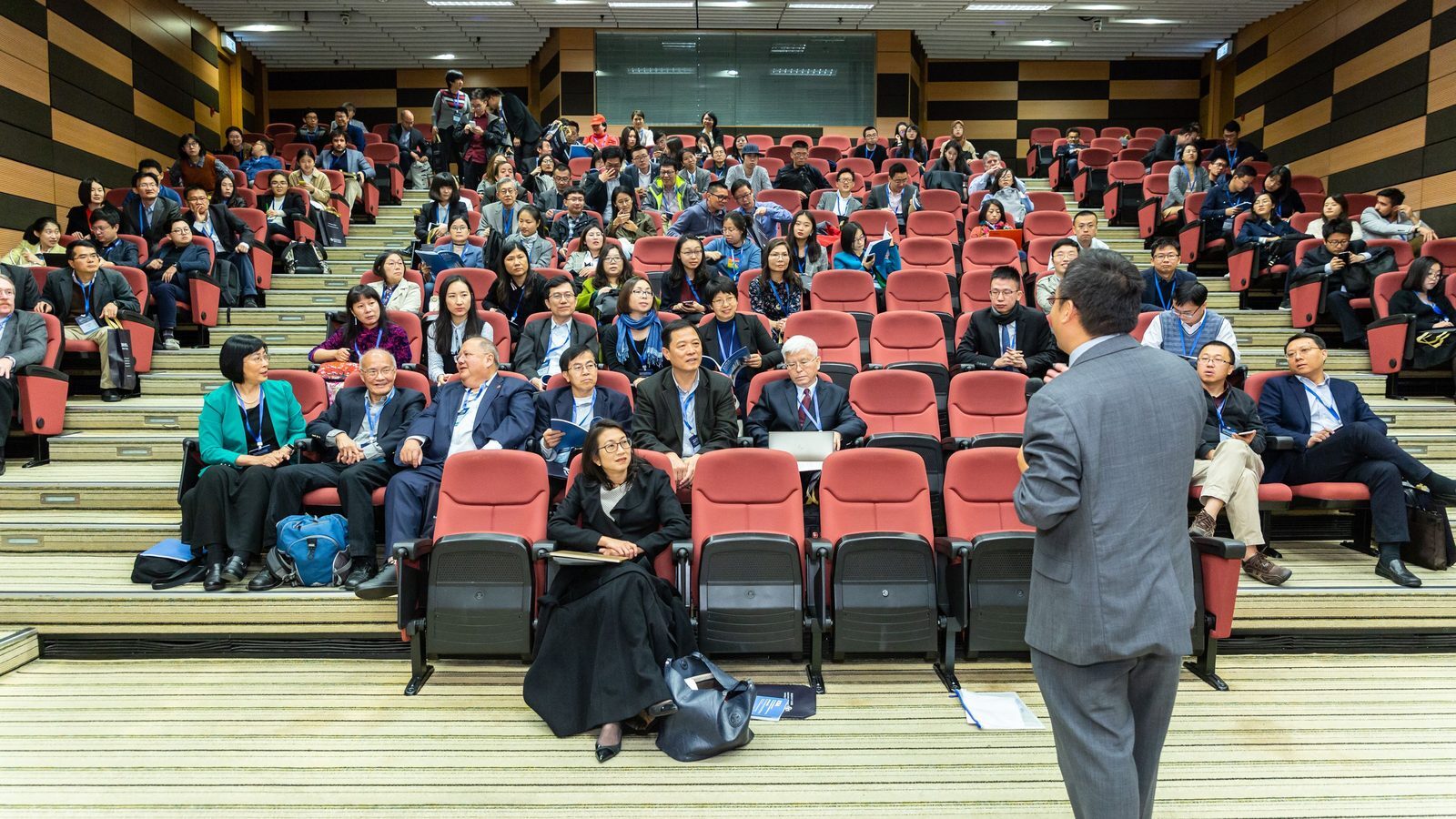 A speaker presenting to a seated conference audience
